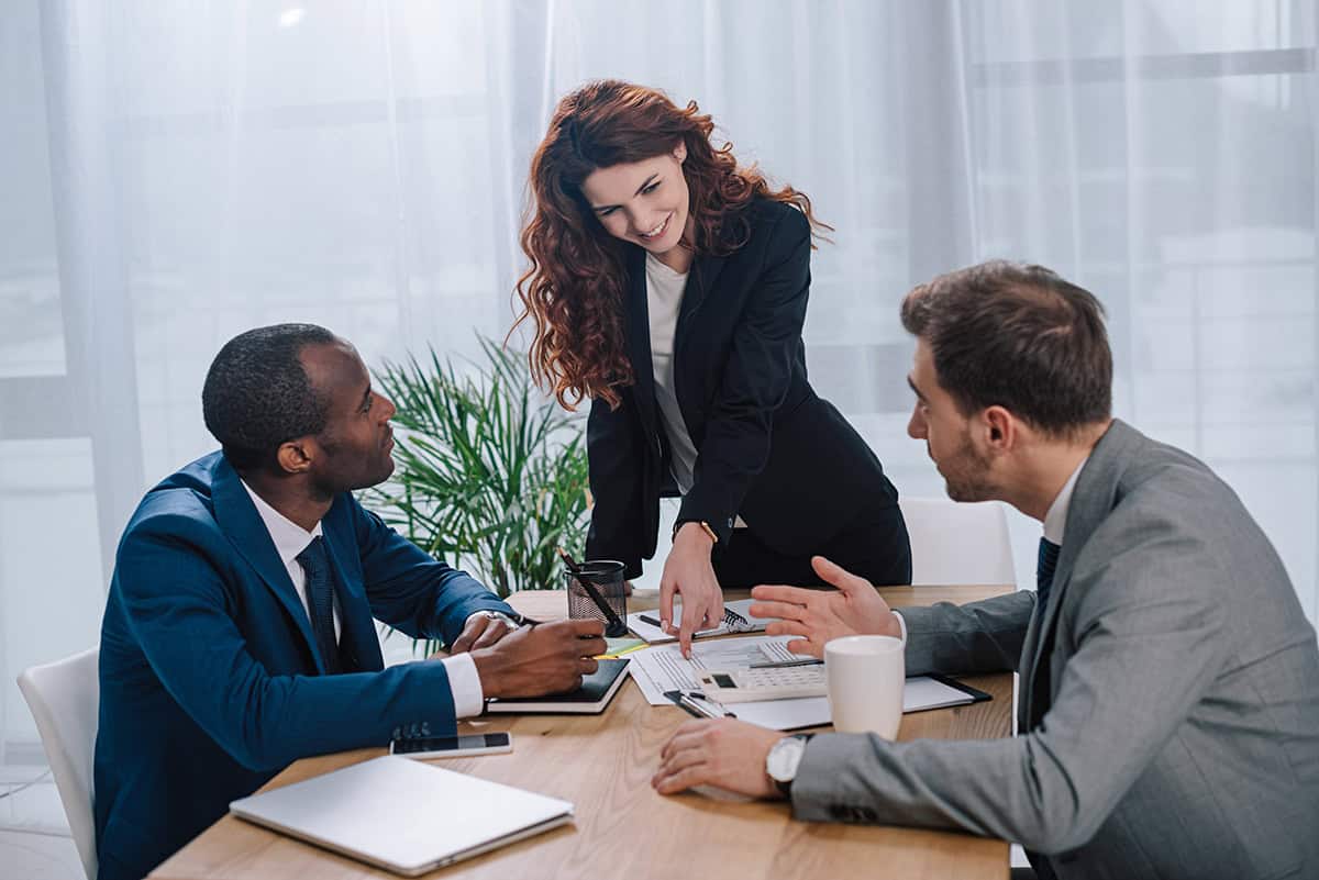 Estate planning professionals discussing documents with clients at a meeting table.