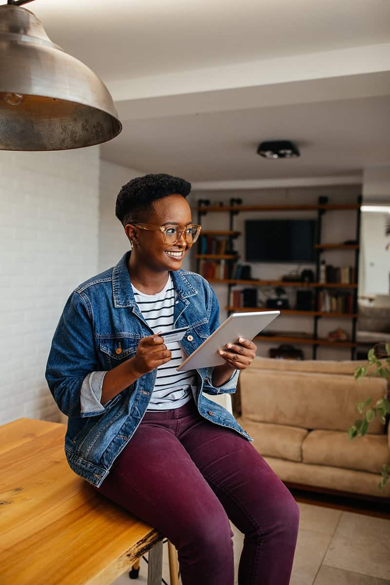 Smiling woman using a tablet at home, symbolizing the convenience of online estate planning.