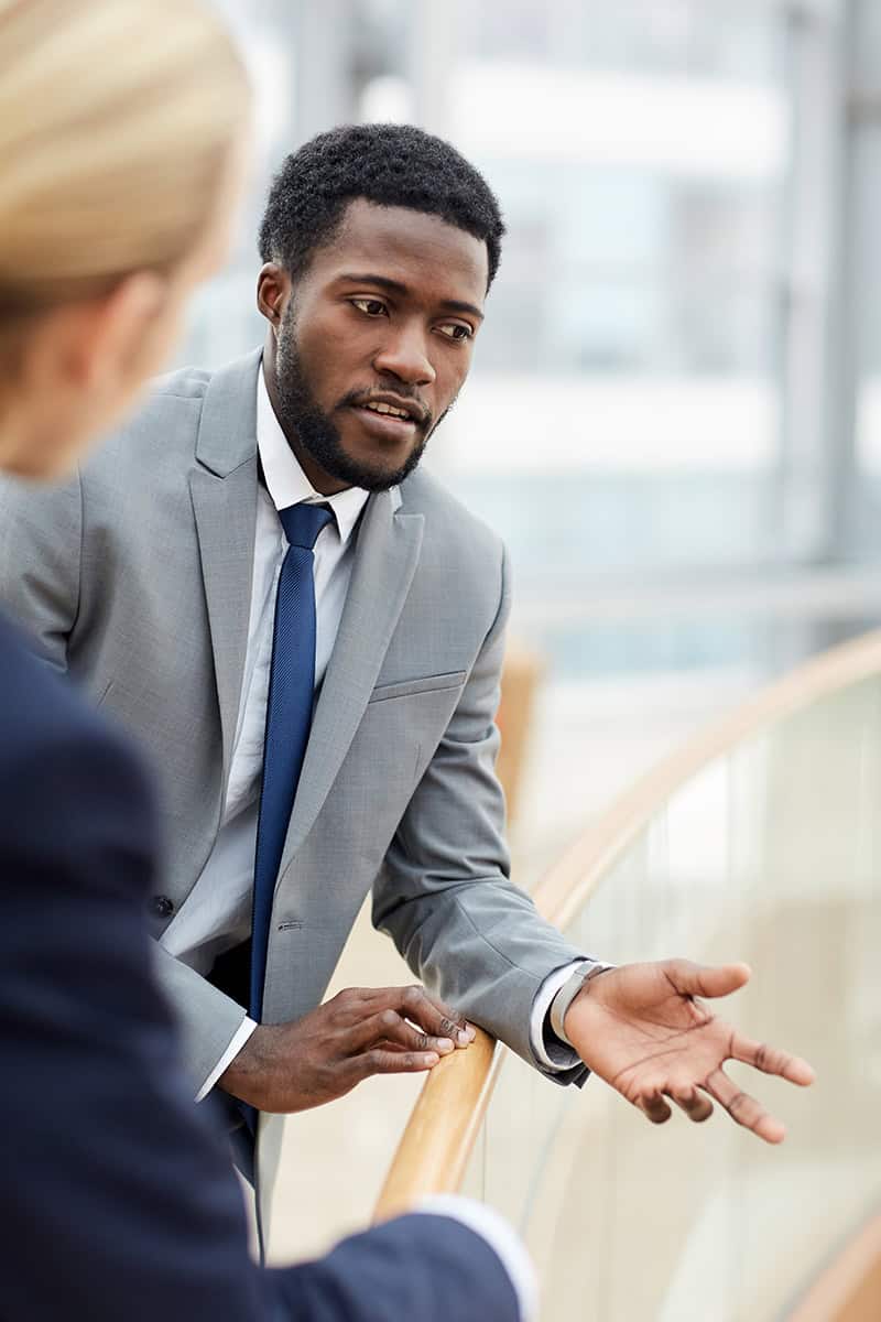 Professional lawyer in a grey suit speaking with a client.