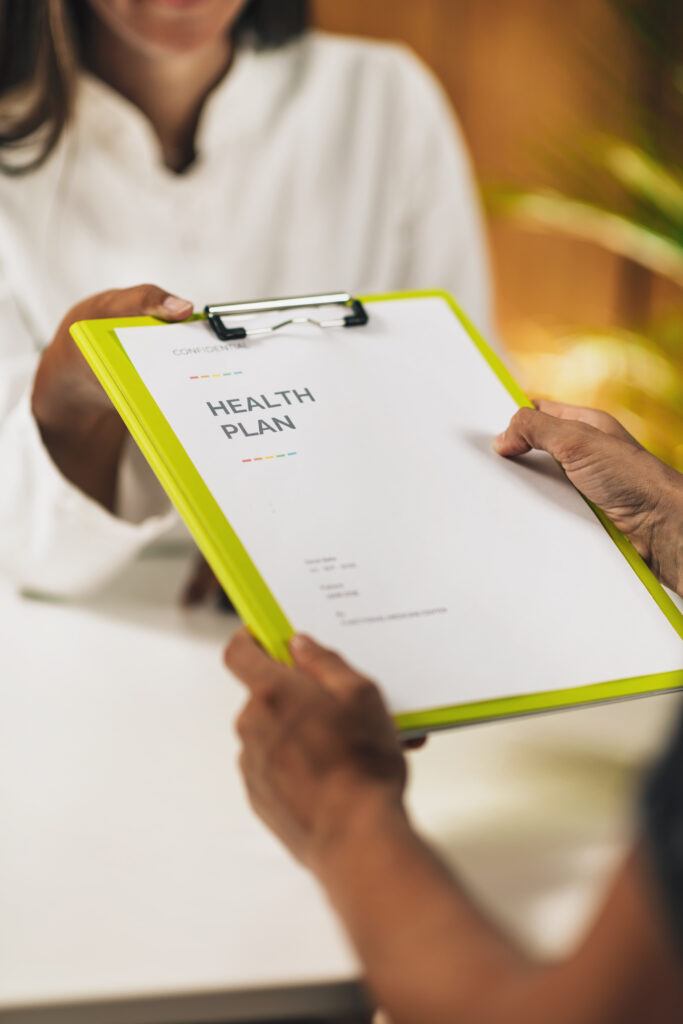 Person receiving a health plan document during a medical planning appointment