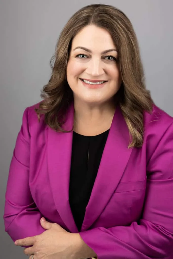 Jennifer Wright, a professional attorney, smiling confidently while wearing a vibrant pink blazer.